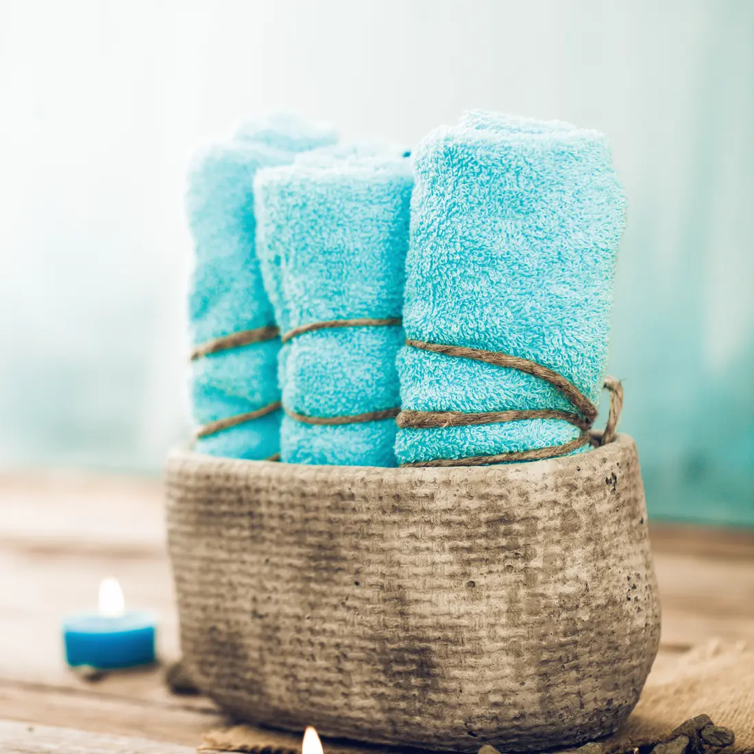 rolled spa towels with candles and stones