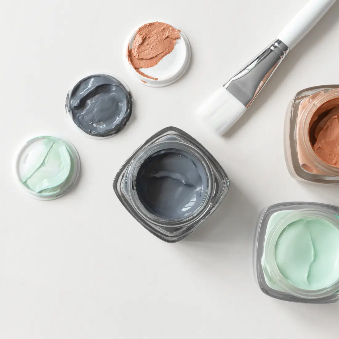 jars of colorful face masks and a brush