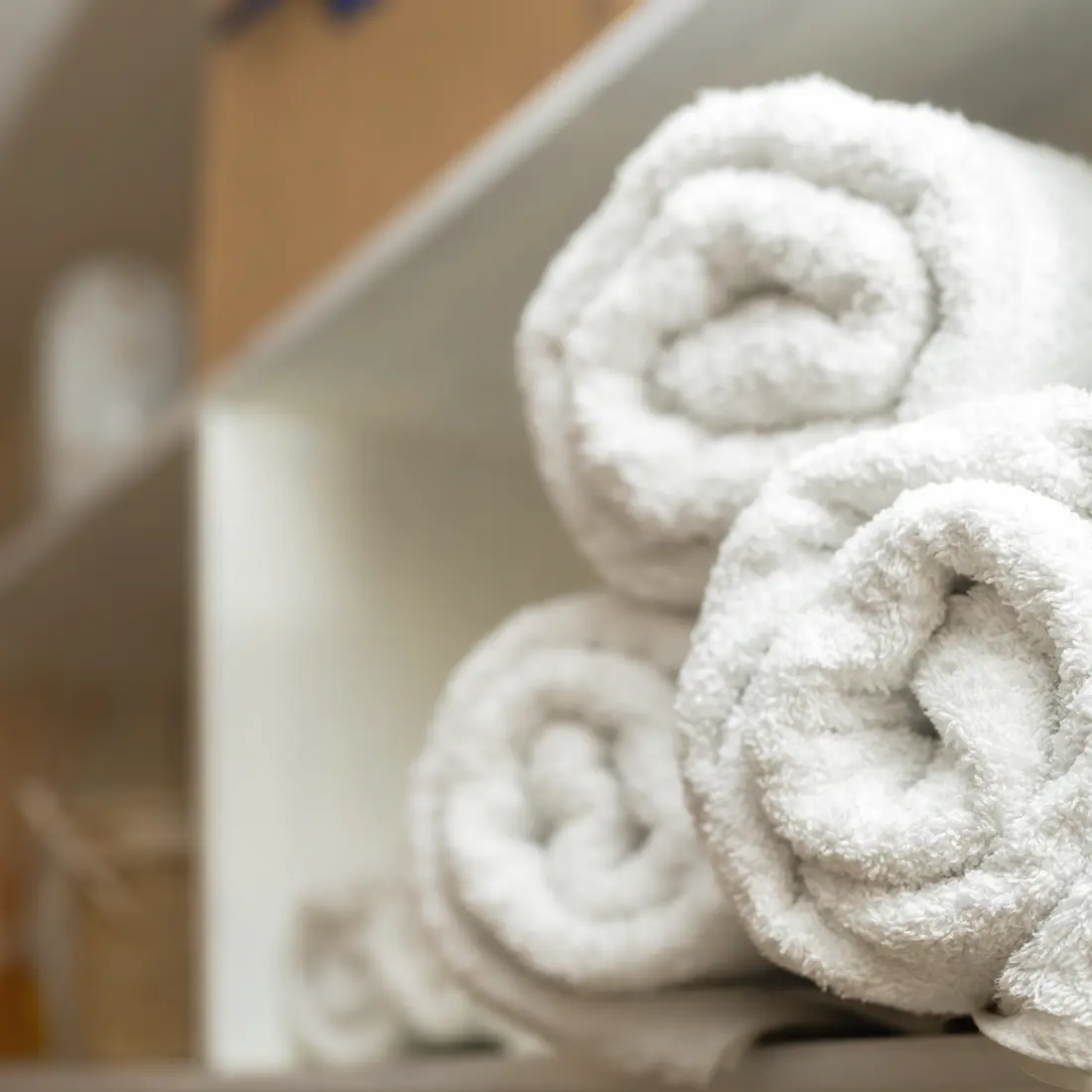 rolled white spa towels on a shelf