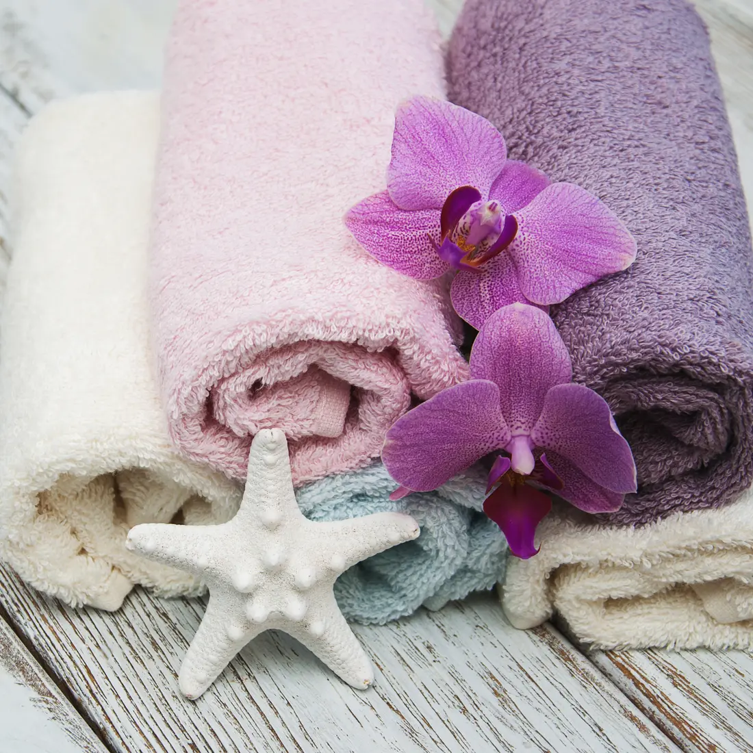rolled towels with orchids and starfish