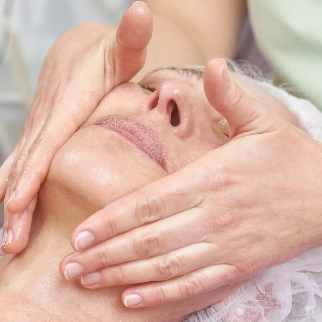 esthetician massaging woman's face