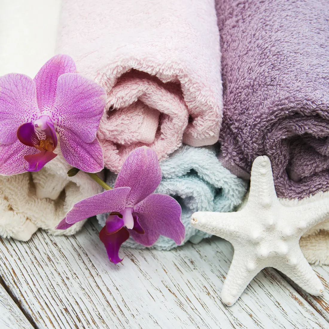rolled towels with orchids and starfish