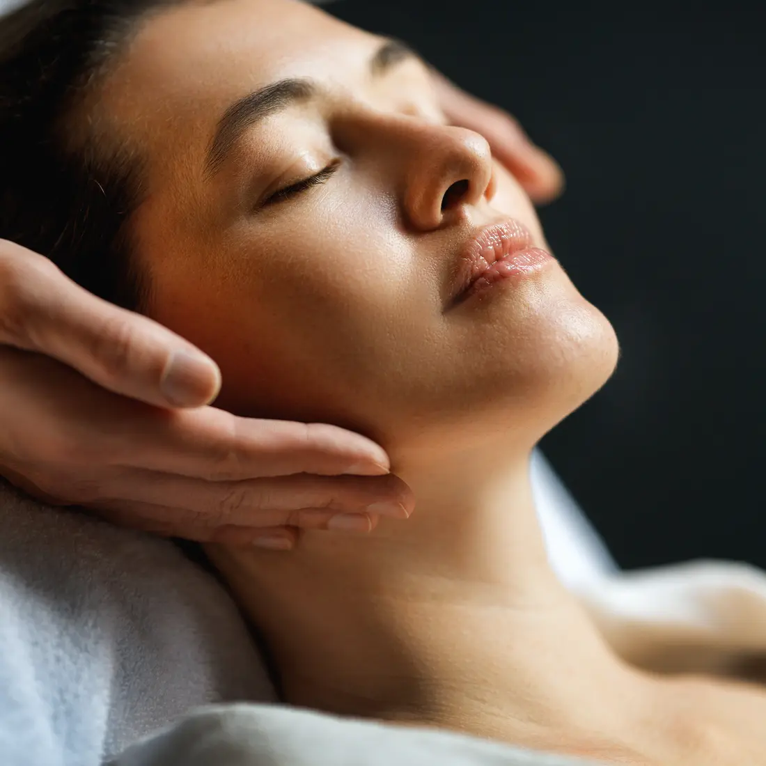 woman receiving facial massage with eyes closed