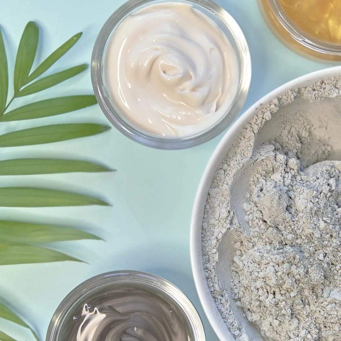 jars of skincare products and clay mask