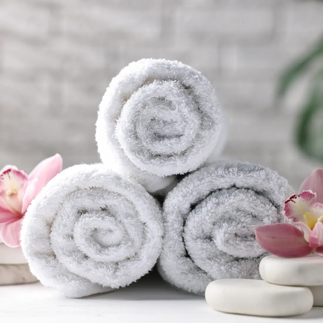 rolled towels with orchids and stones