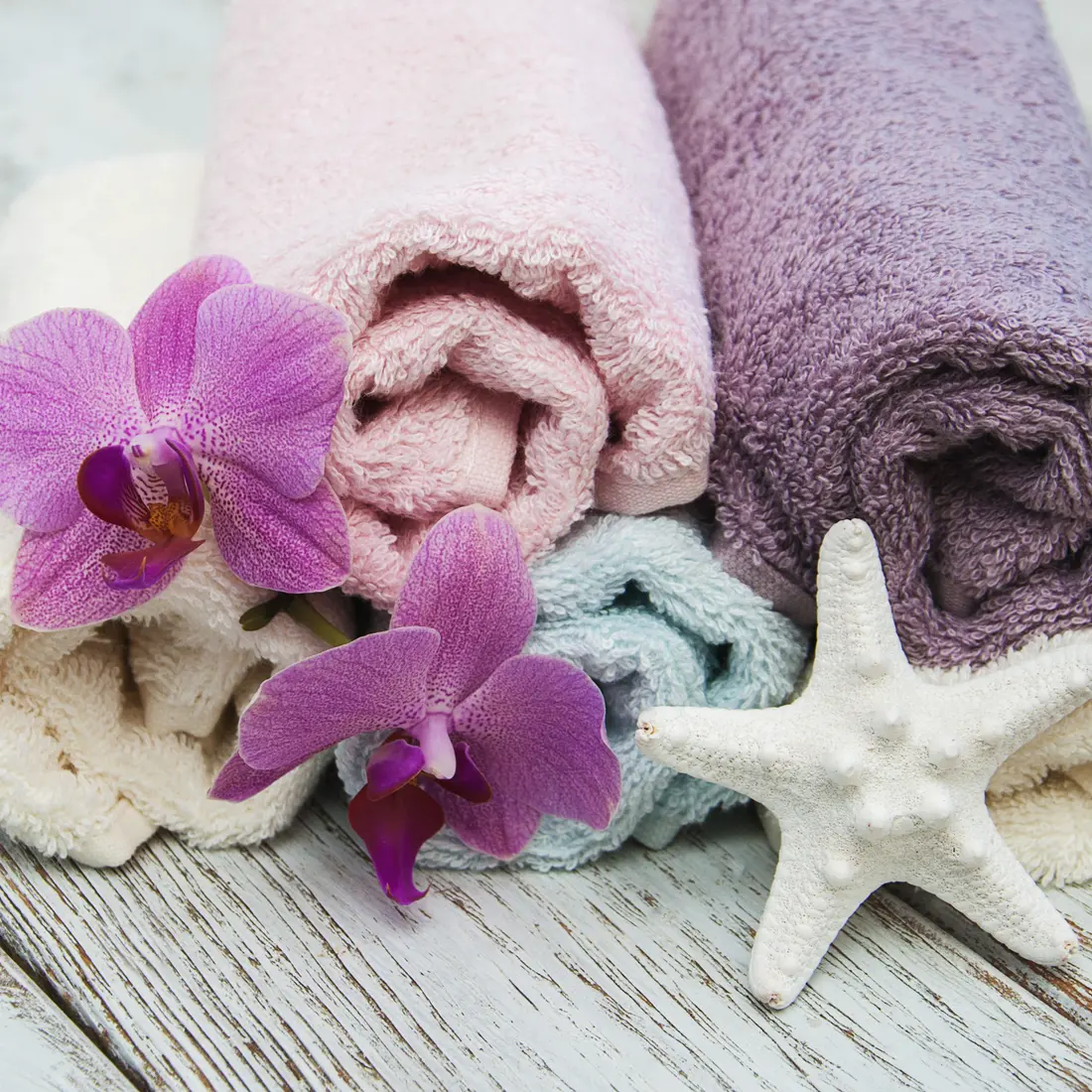rolled towels with orchids and starfish