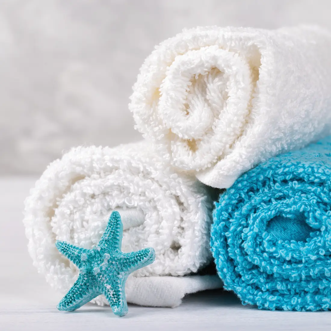 rolled white and blue towels with starfish decoration