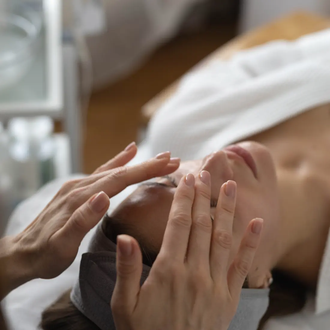 esthetician massaging client's face during facial treatment