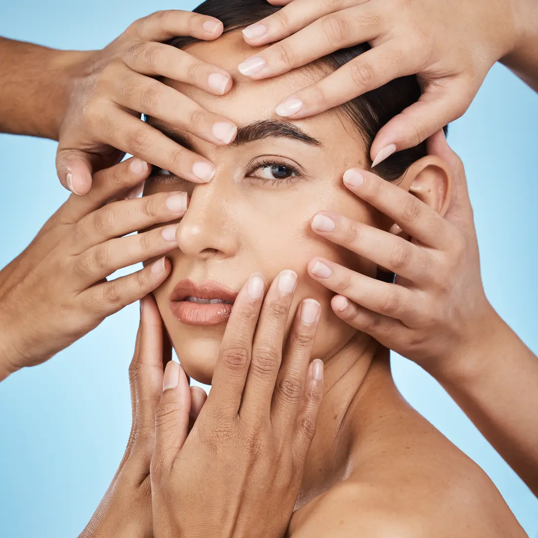 woman's face surrounded by many hands