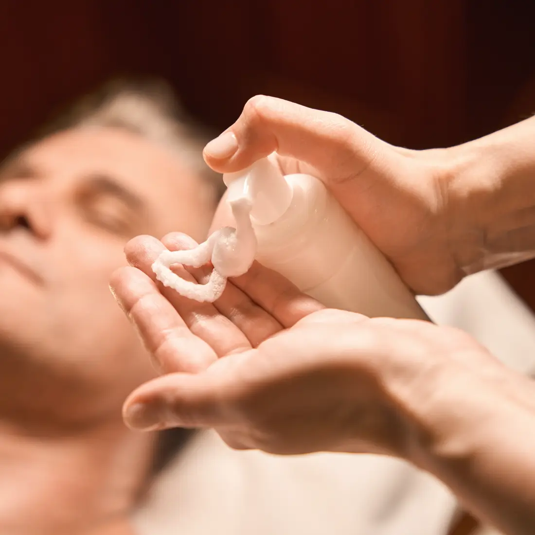 hands dispensing foam from a bottle onto a palm