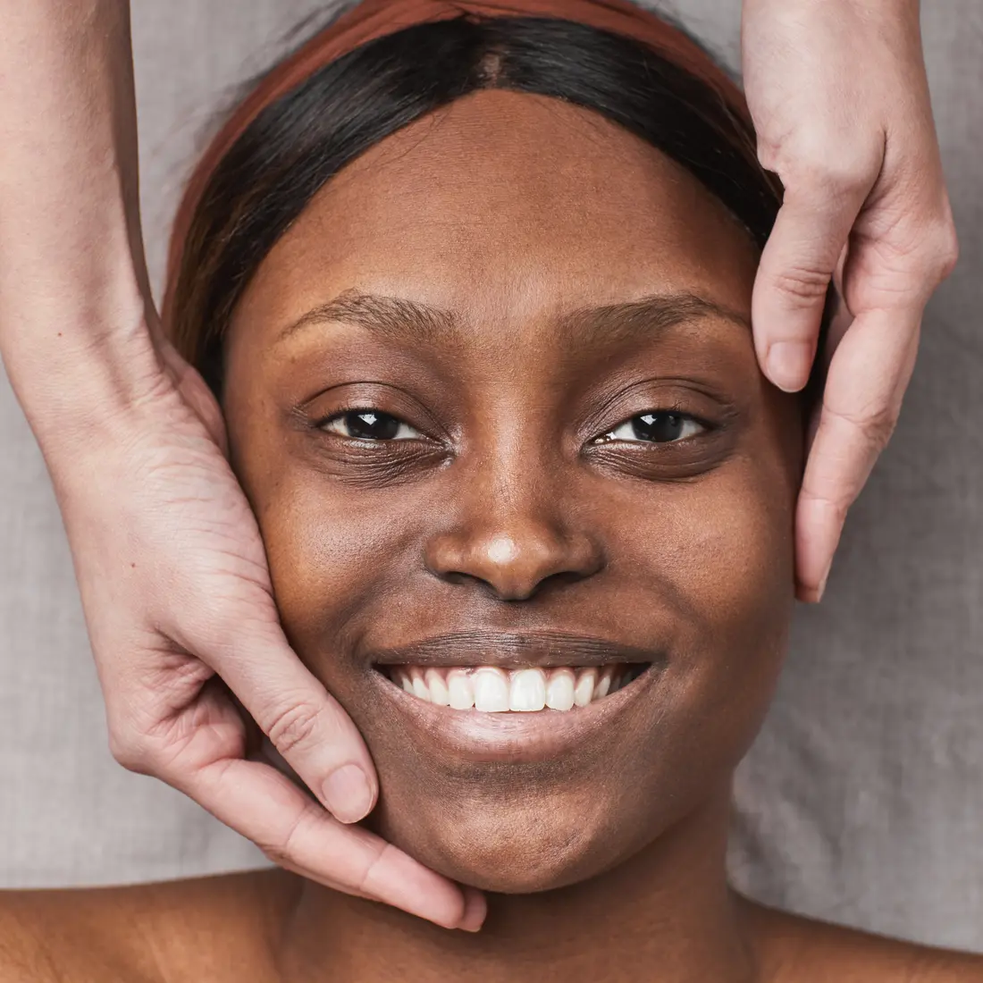 woman receiving facial massage with hands on face