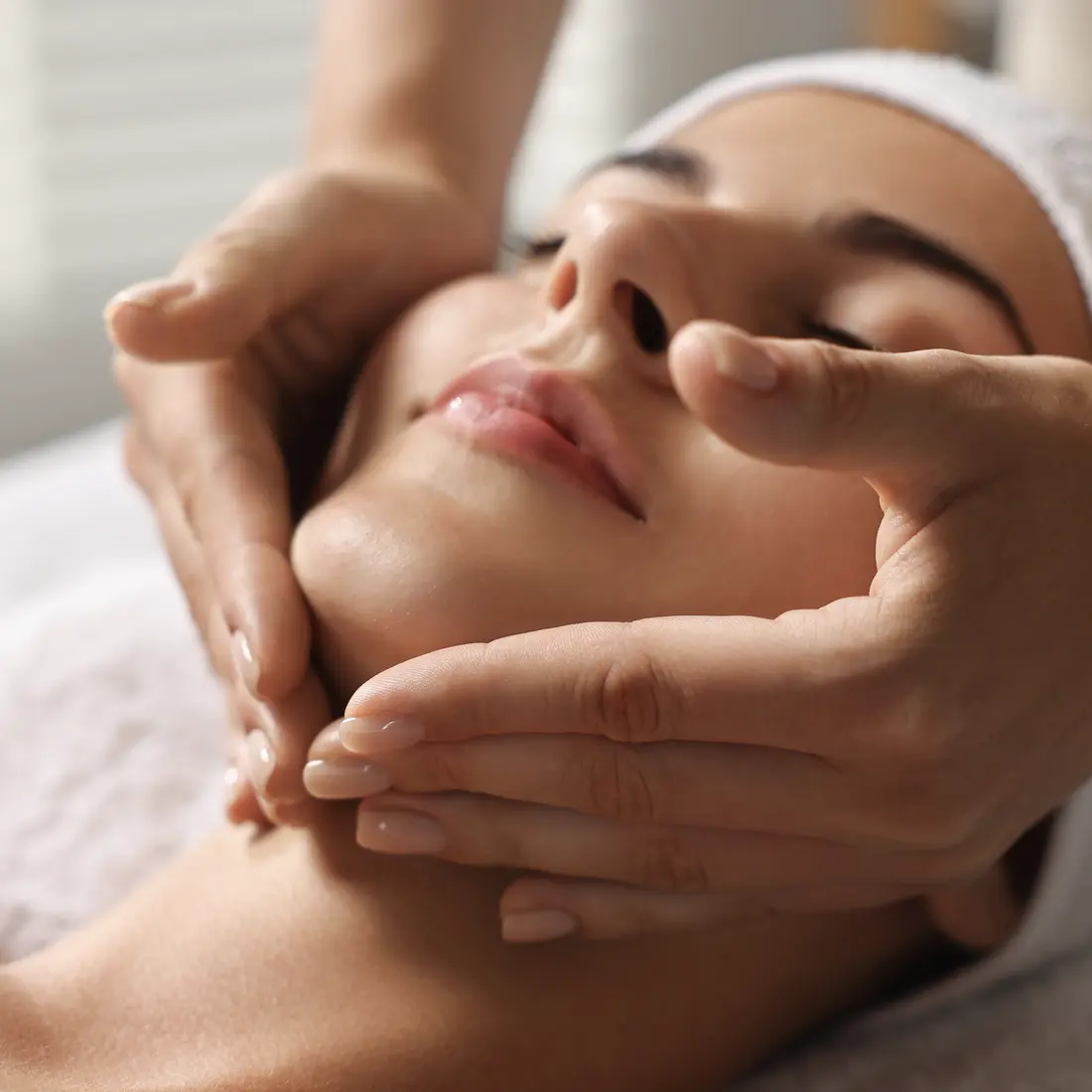 woman receiving facial massage with hands