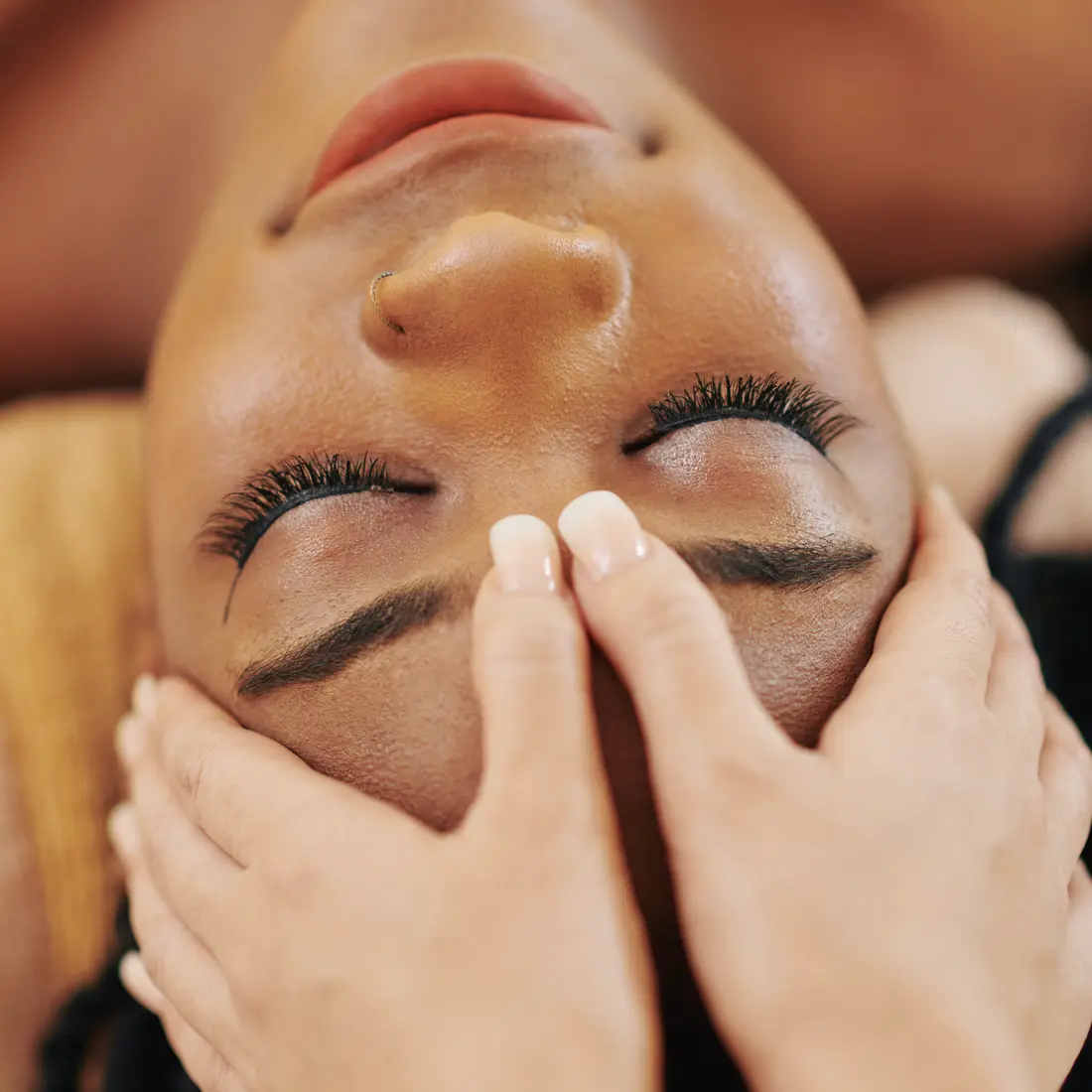 woman receiving a facial massage with eyes closed