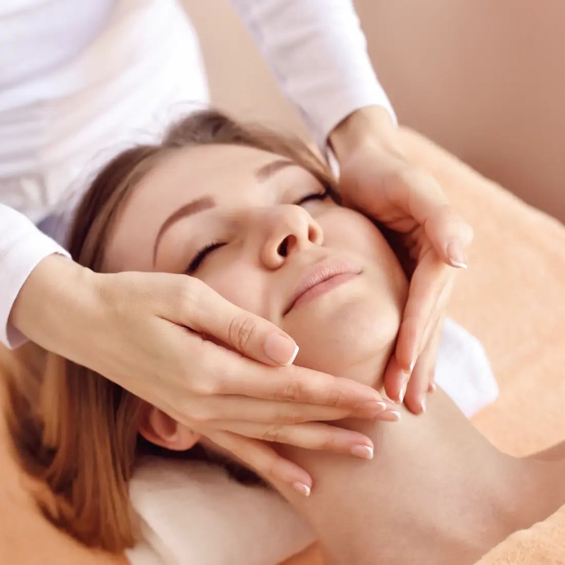 woman receiving a facial massage with closed eyes
